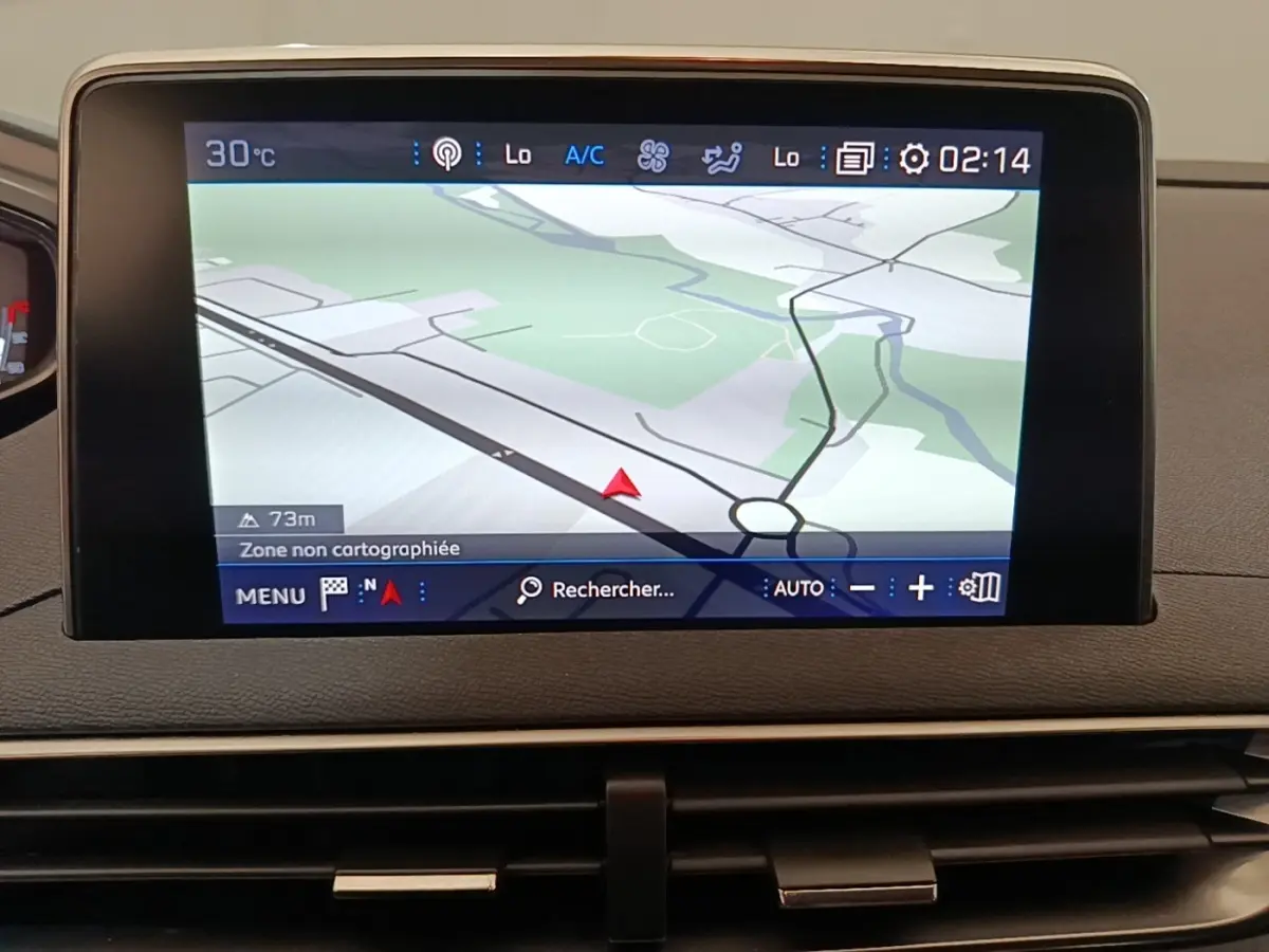 Écran tactile central du tableau de bord du Peugeot 3008 noir, affichant la navigation 3D et la température extérieure.