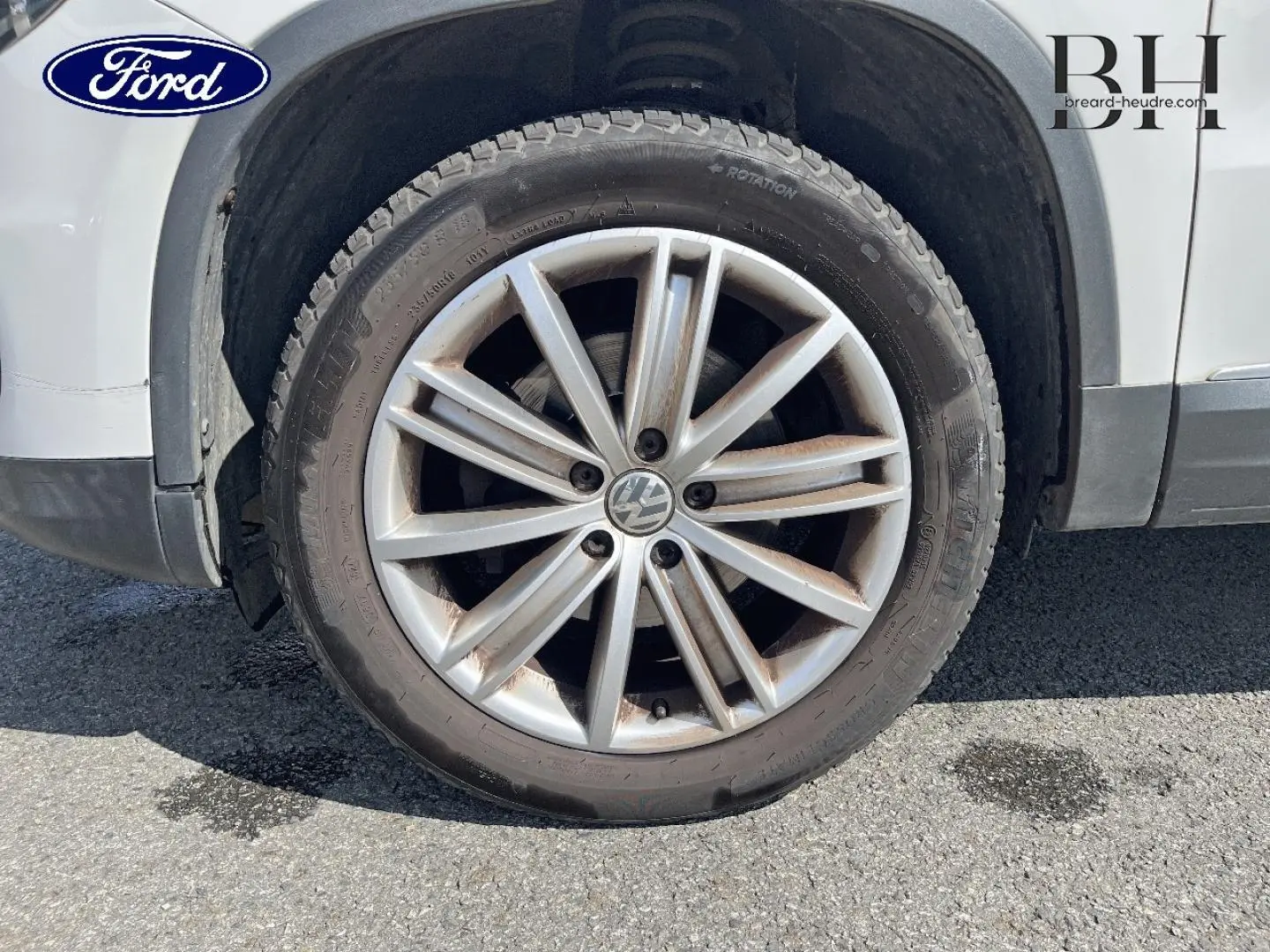 Gros plan sur la roue avant gauche avec jante alu 17 pouces du Volkswagen Tiguan blanc Candy de 2013.