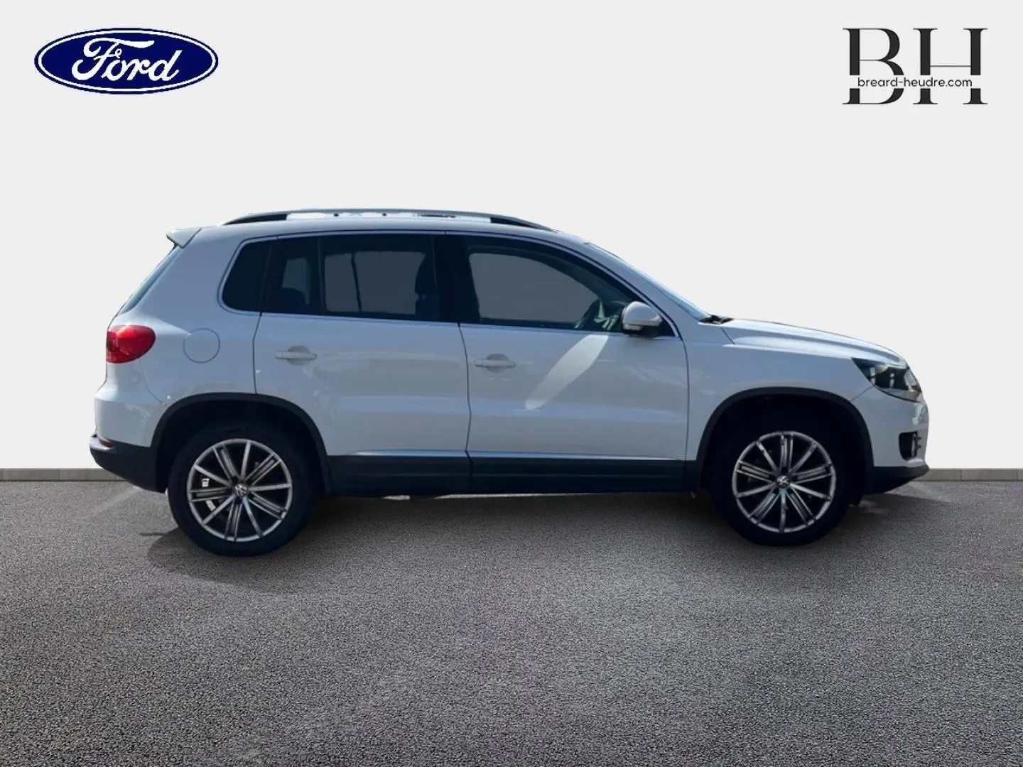 Vue de profil côté gauche d'un Volkswagen Tiguan blanc Candy avec jantes alliage 17 pouces sur fond neutre.