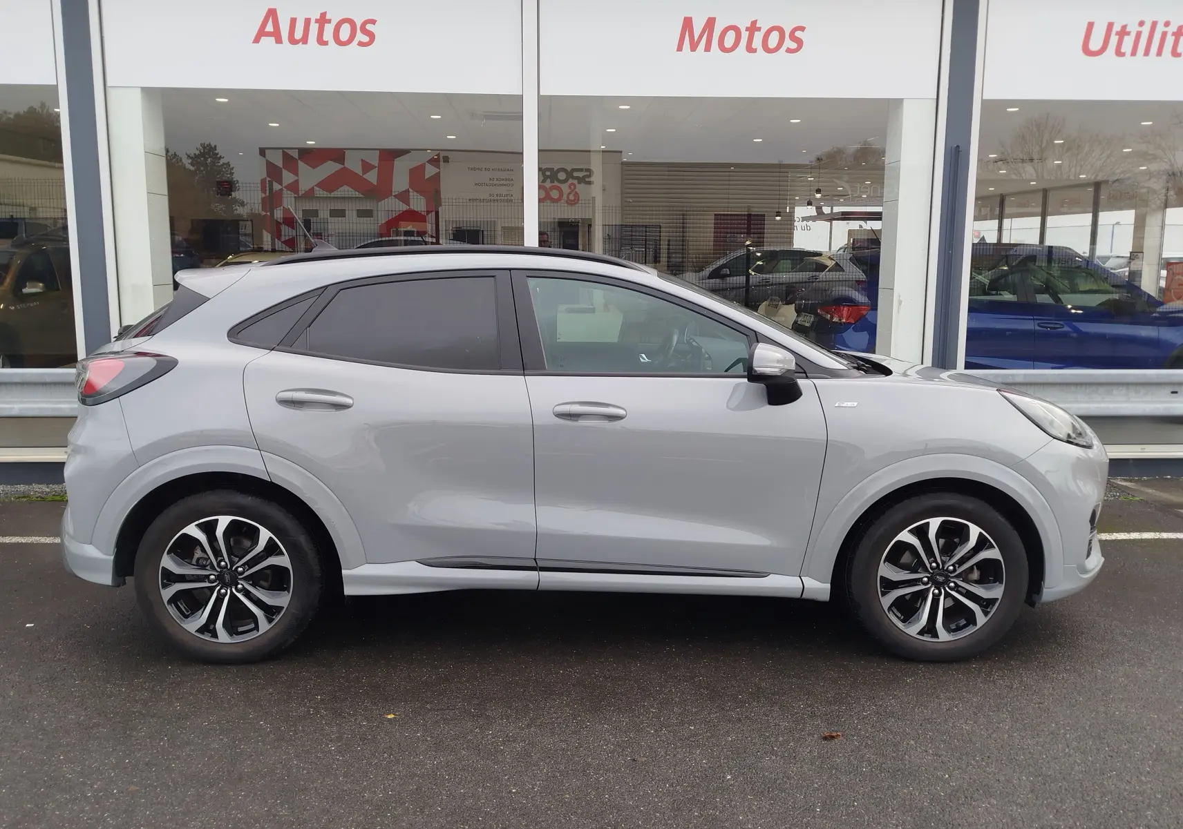 Ford Puma 1.0 EcoBoost 125ch ST-Line gris Fashion Matter vue de profil côté gauche avec jantes bi-ton et vitres teintées.
