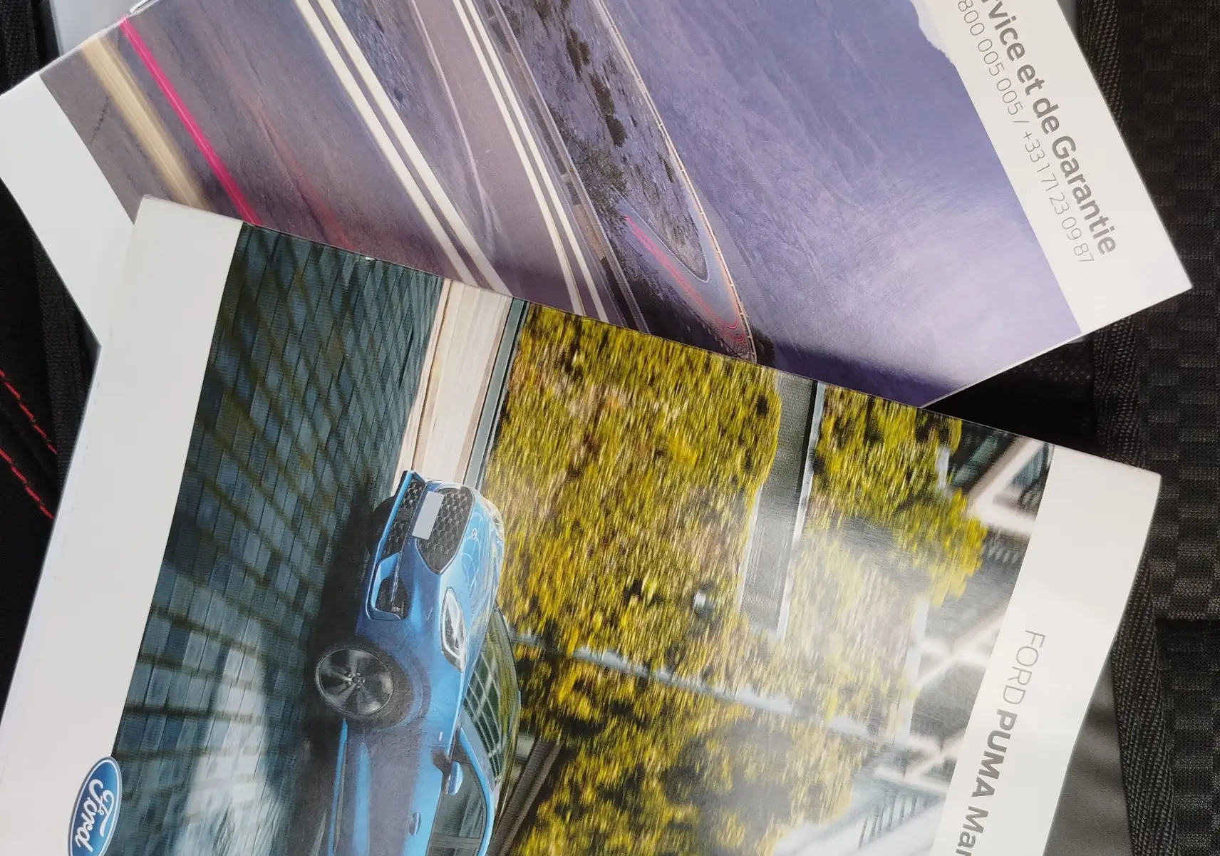 Vue de profil gauche d'une Ford Puma bleu vif en milieu urbain avec bâtiments et arbres en arrière-plan.