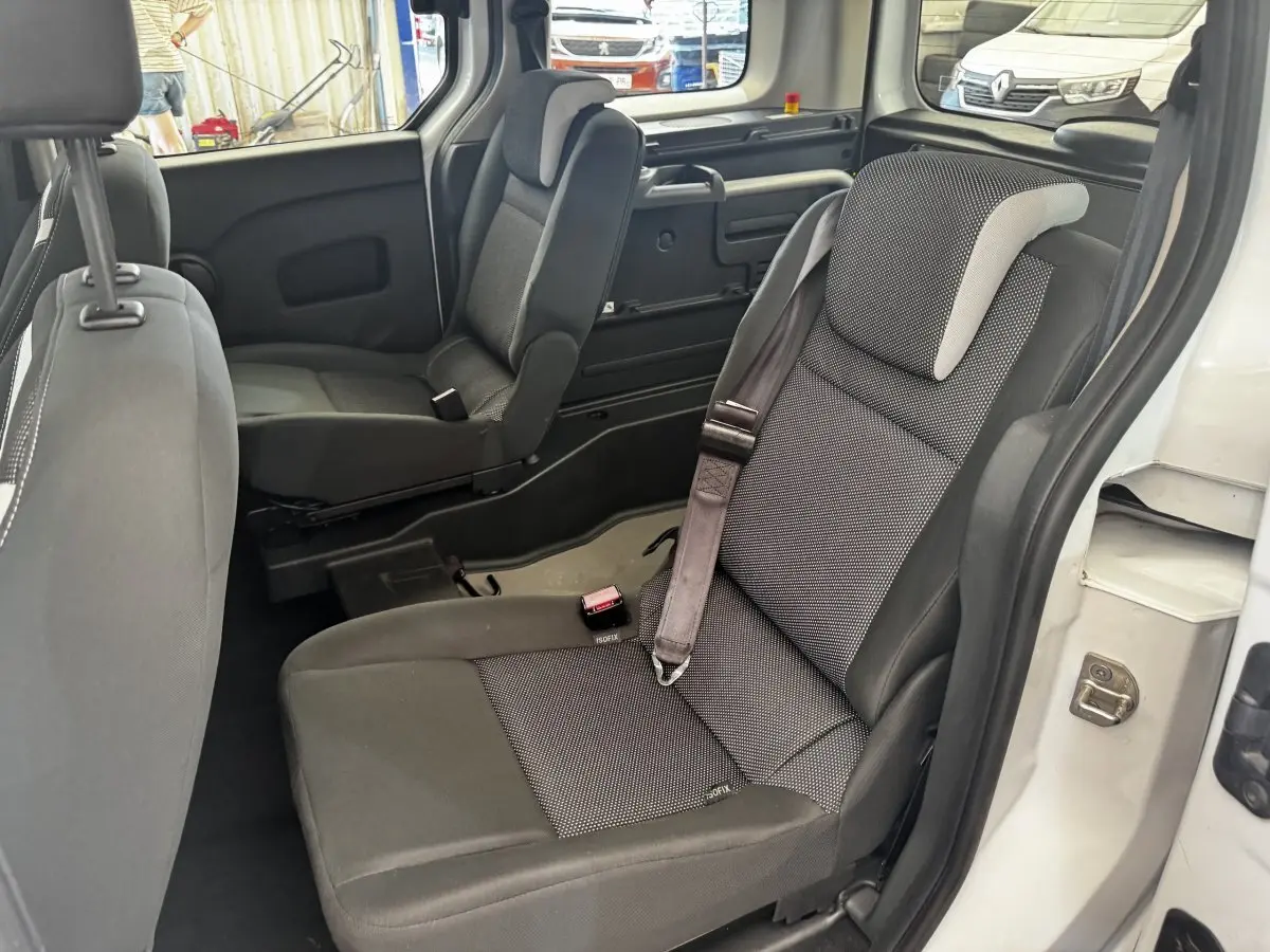Vue intérieure côté droit sur les sièges arrière gris du Renault Kangoo blanc, avec ceintures de sécurité visibles.
