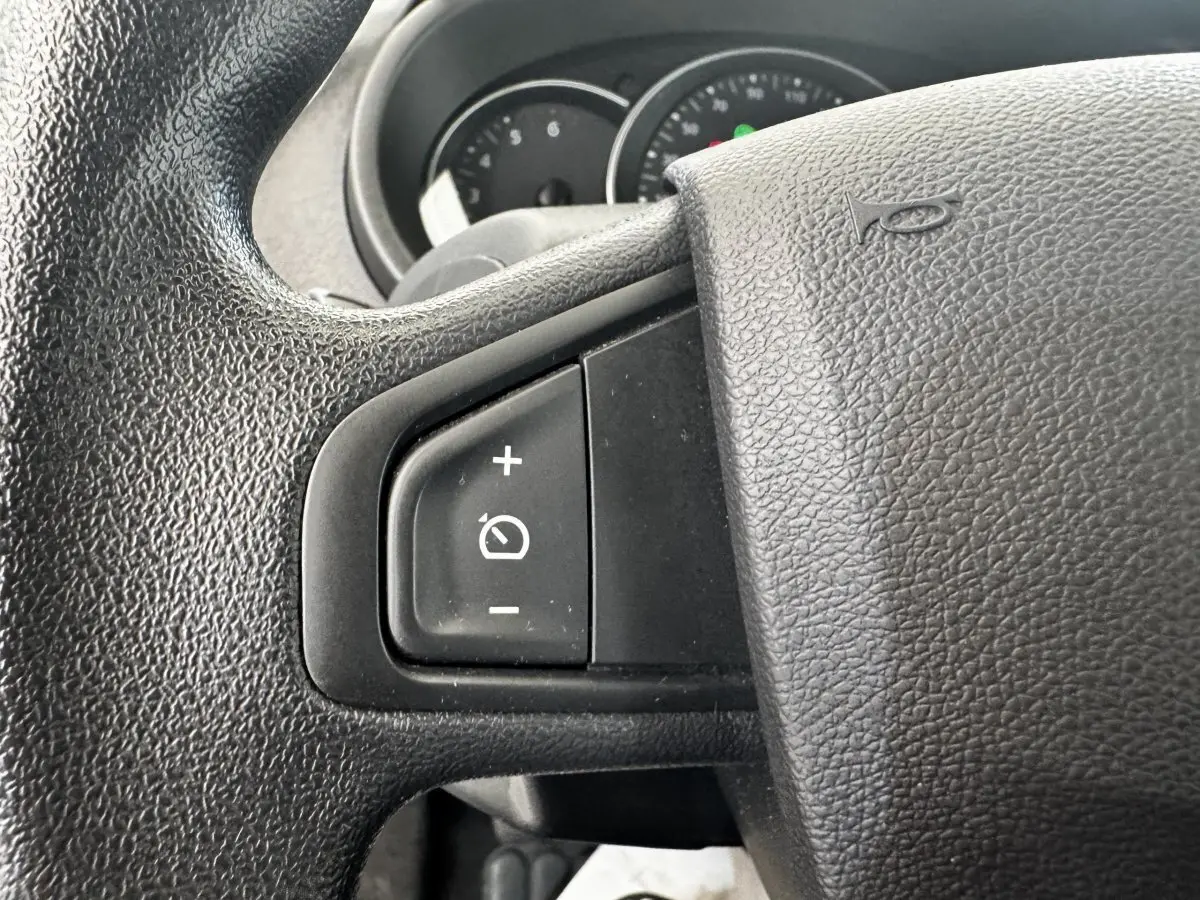 Gros plan sur le volant noir du Renault Kangoo 2016 avec commandes du régulateur de vitesse visibles.