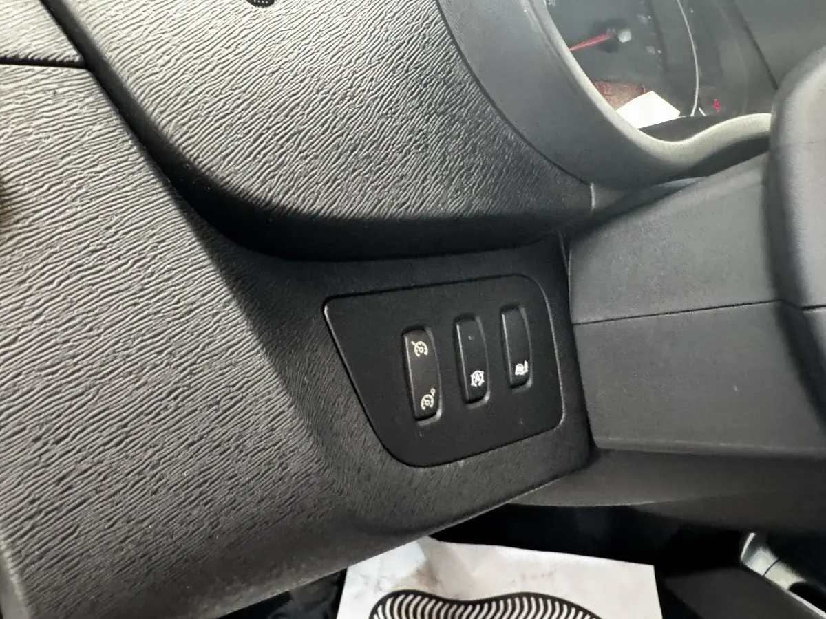 Détail des commandes situées à gauche du volant dans l'habitacle noir du Renault Kangoo Zen 2016.