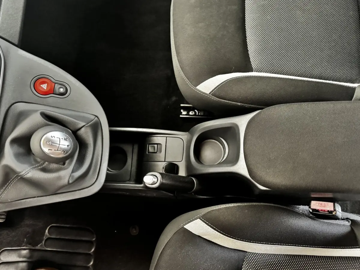 Vue plongeante sur la console centrale et les sièges noirs avec surpiqûres grises du Renault Kangoo Zen 2016.