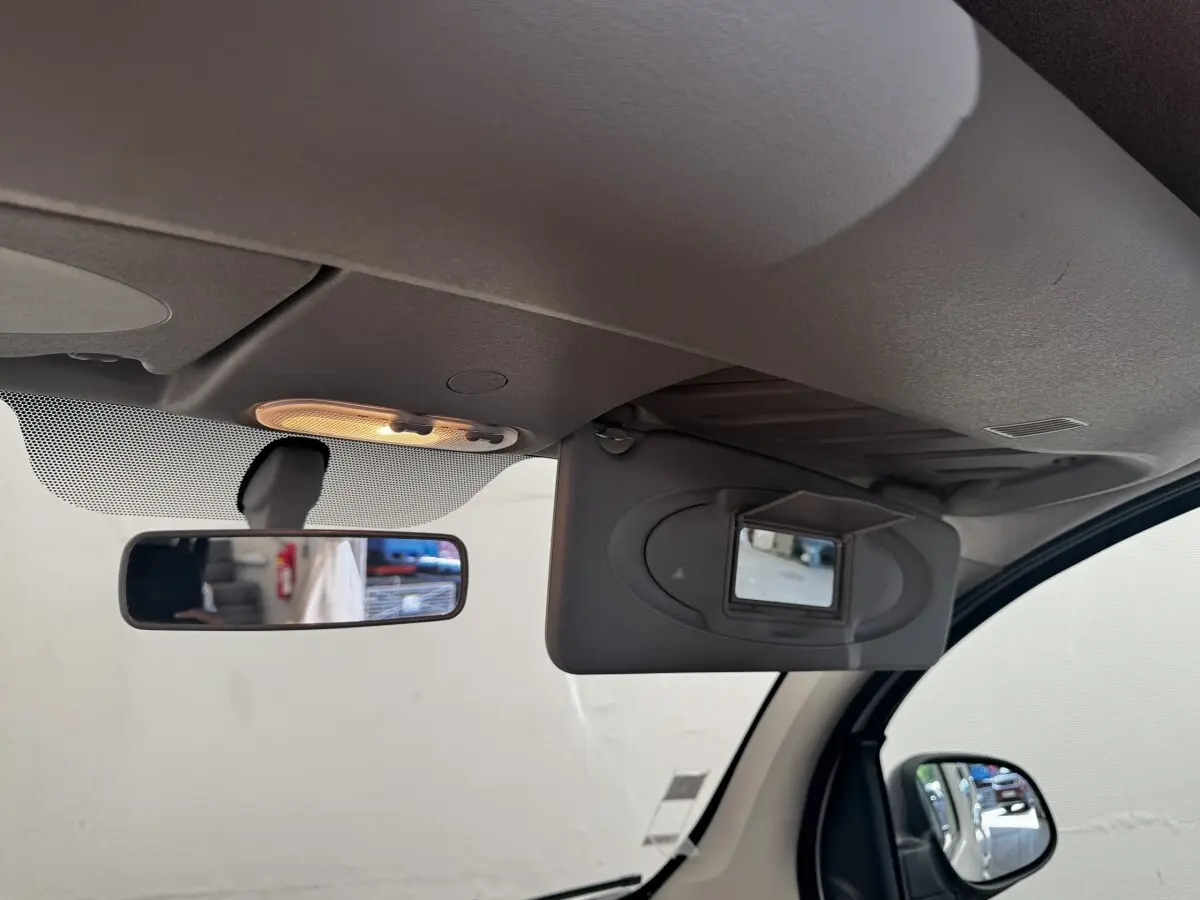 Intérieur du Renault Kangoo Zen 2016, vue sur pare-soleil avec miroir et rétroviseur central allumé.