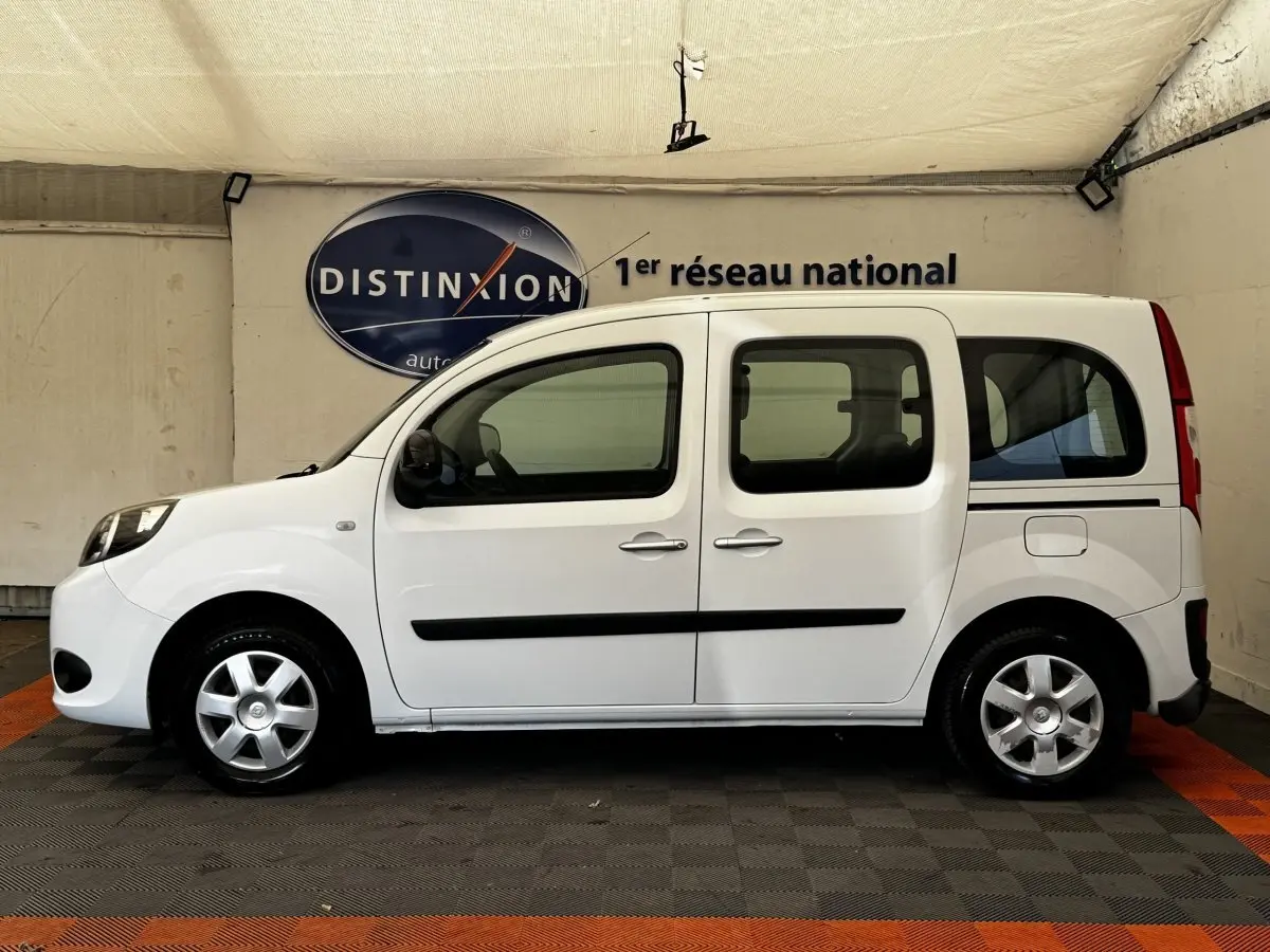 Profil droit d’un Renault Kangoo Zen blanc de 2016, utilitaire compact avec portes coulissantes et jantes acier.