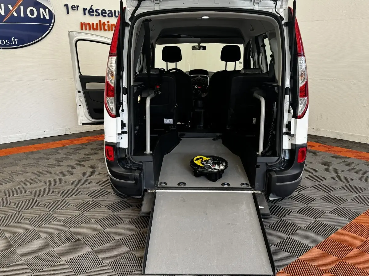 Vue arrière du Renault Kangoo blanc 2016 avec porte ouverte et rampe d'accès déployée, intérieur visible.