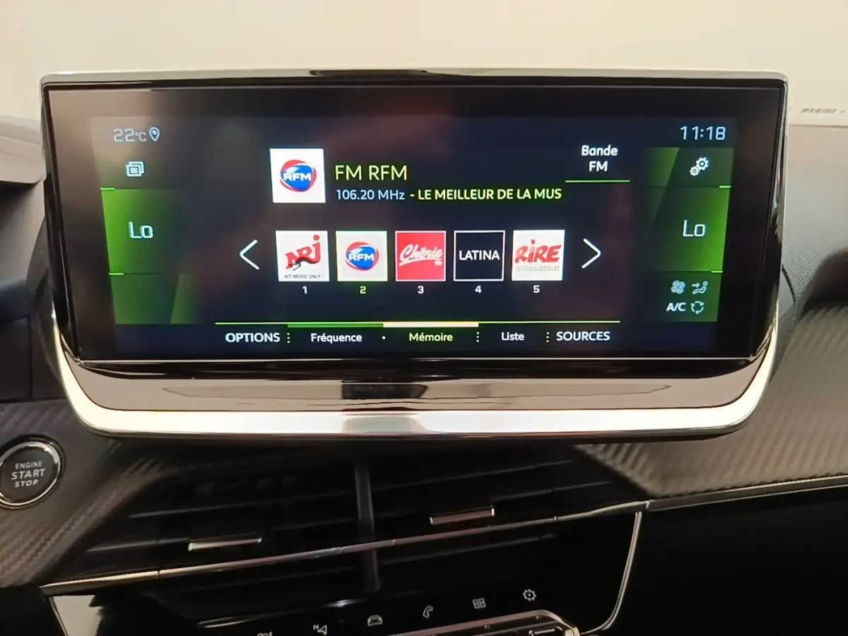 Écran tactile central de 10 pouces du Peugeot 2008 blanc, affichant la radio FM avec commandes intégrées.