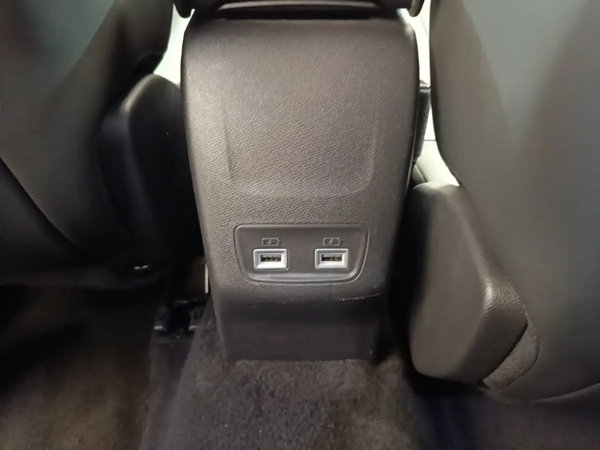 Prise double USB noire vue de face entre les sièges arrière d’un Peugeot 2008 blanc.