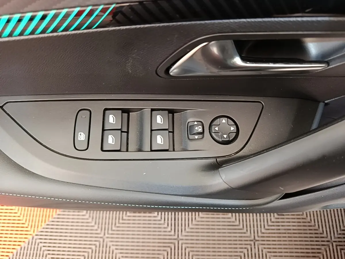 Vue rapprochée de la porte côté conducteur d'une Peugeot 2008 blanche, avec commandes électriques des vitres et rétroviseurs.