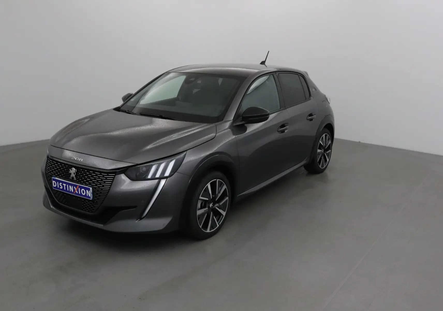 Peugeot 208 gris platinium avec toit noir, vue 3/4 avant droit dans un studio lumineux.