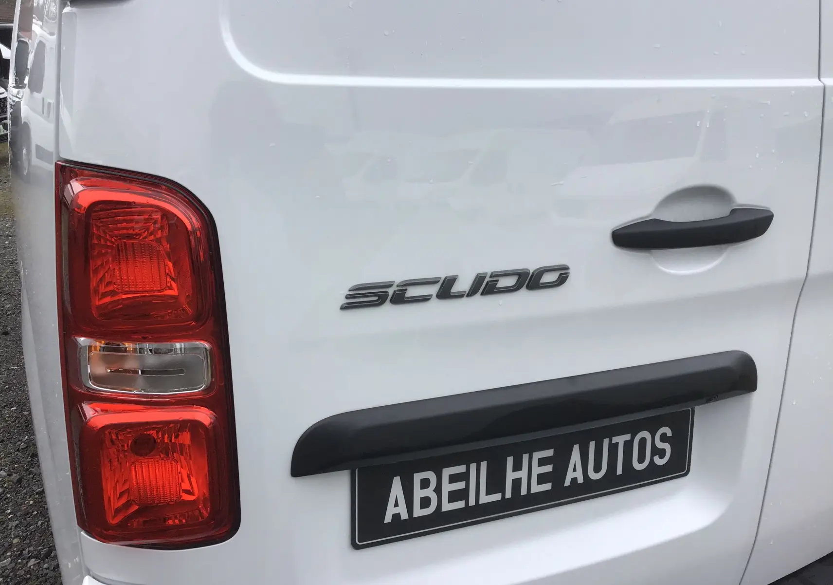 Gros plan sur l’arrière gauche blanc du FIAT Scudo Fourgon avec feux rouges et poignée noire.