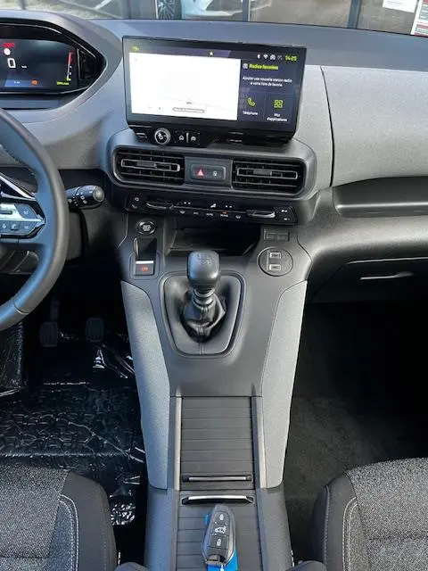 Vue intérieure centrée sur la console centrale du Peugeot Rifter 2024, avec écran tactile, boîte manuelle et clé posée.