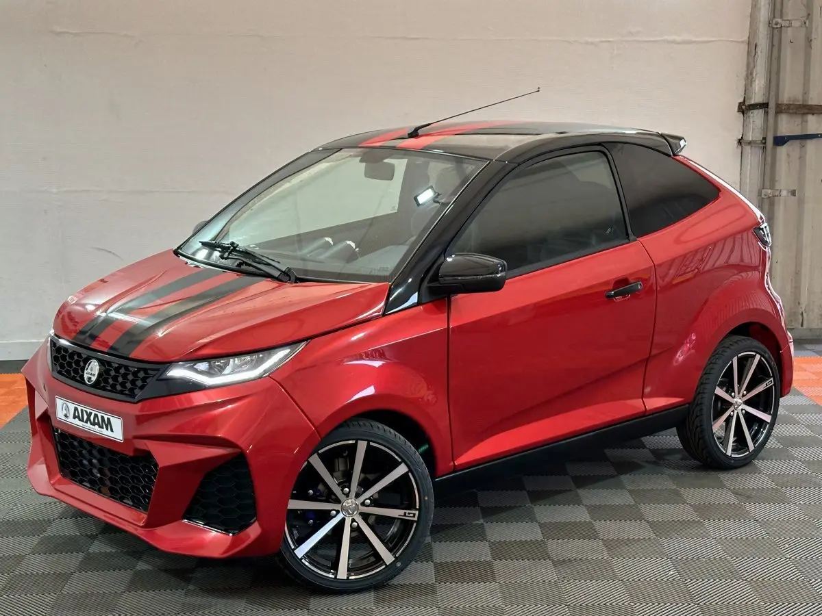 Vue 3/4 avant droit d'une Aixam Ambition rouge 2026 avec bandes noires sur le capot et jantes alliage noires.