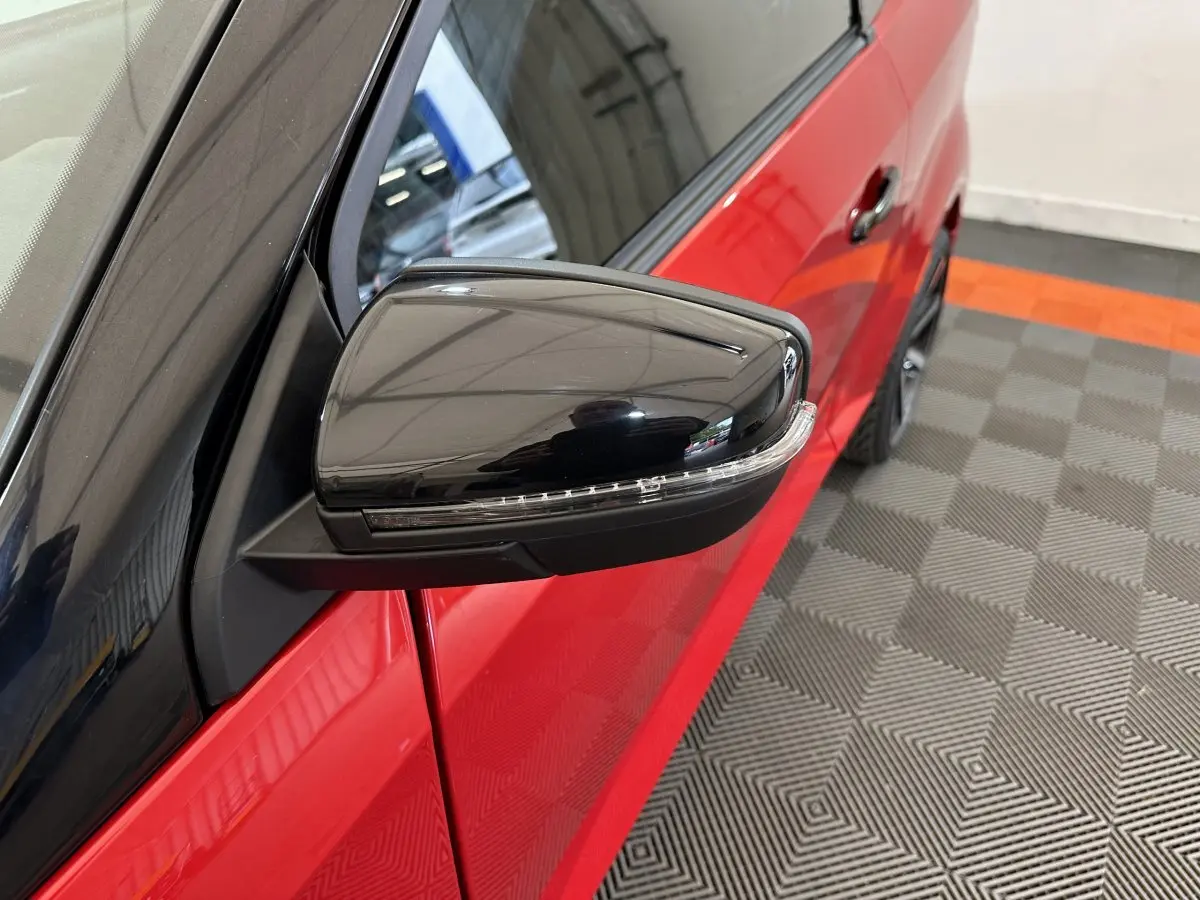 Gros plan sur le rétroviseur extérieur noir côté conducteur d'une Aixam Ambition rouge 2026, avec caméra intégrée.