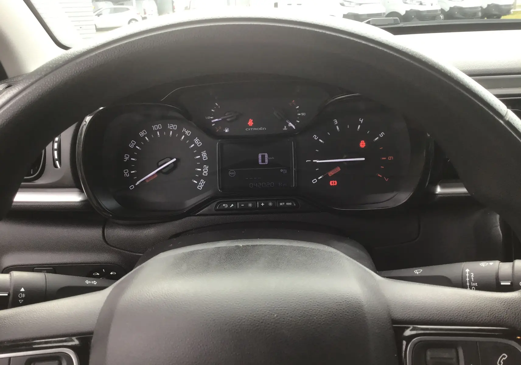 Vue intérieure du tableau de bord de la Citroën C3 blanche 2021, avec compteur analogique et écran digital au centre.