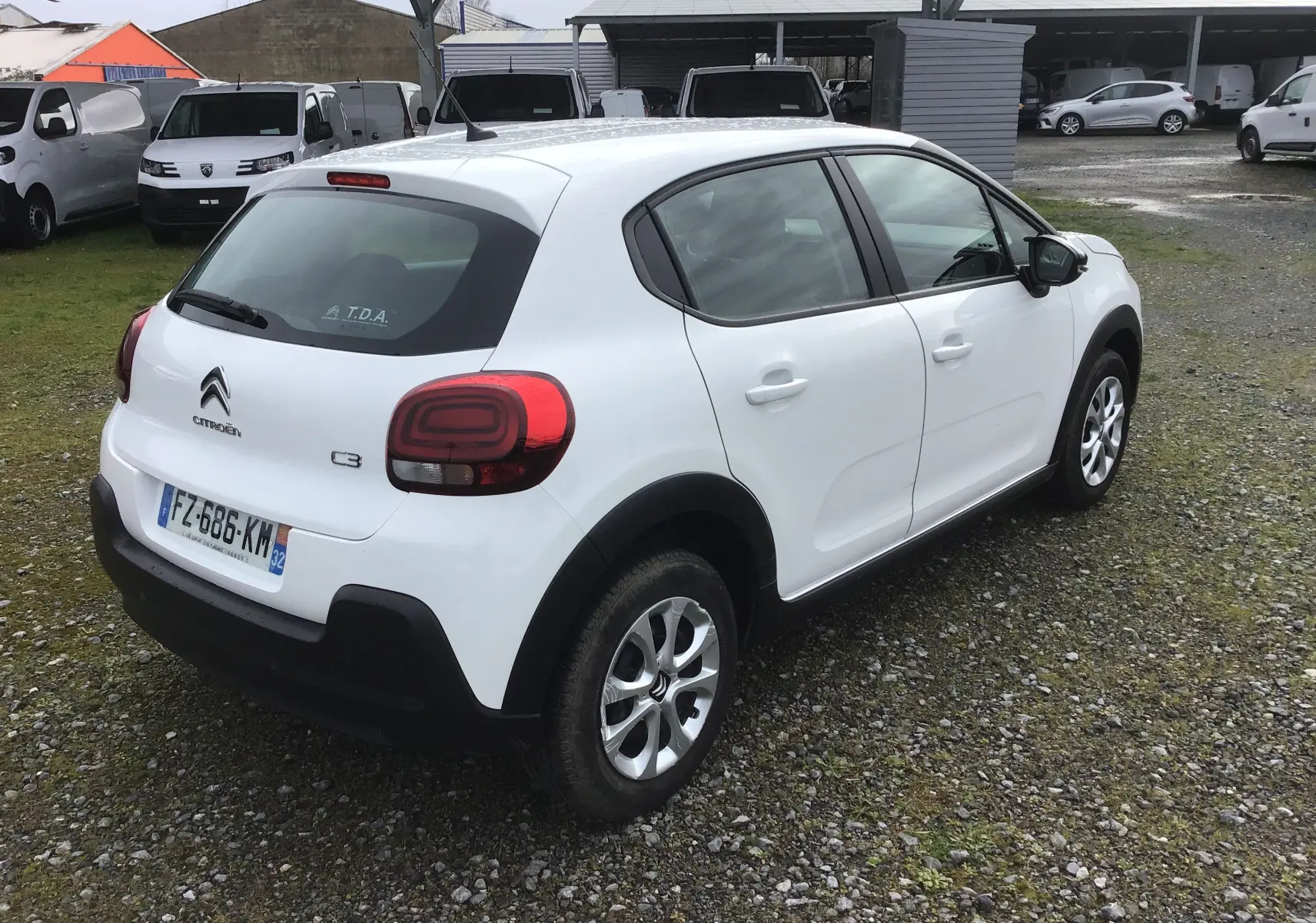 Vue 3/4 arrière droite d'une Citroën C3 blanche 2021 avec feux arrière distinctifs et jantes alliage.