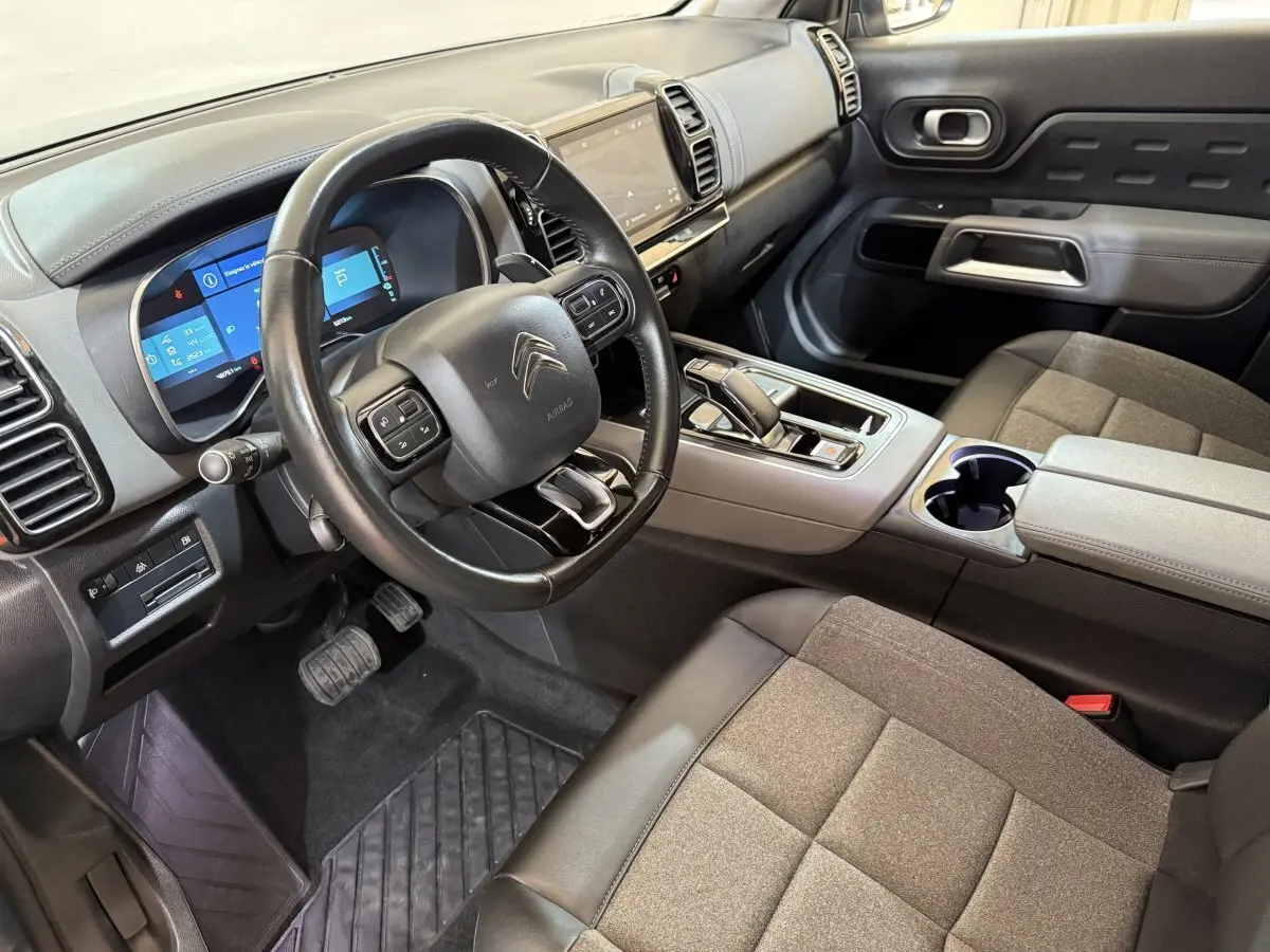 Vue intérieure côté conducteur du Citroën C5 Aircross Hybrid avec tableau de bord numérique et sellerie grise.