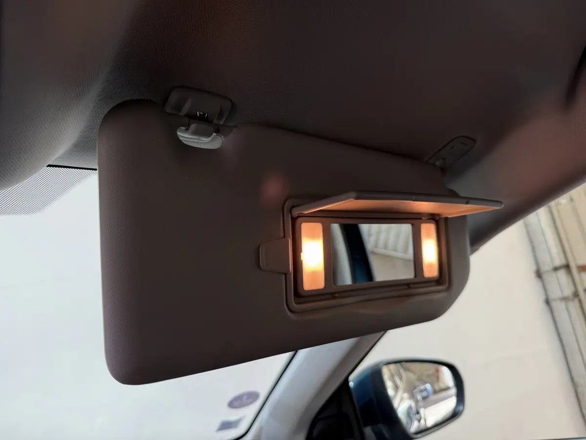 Miroir de courtoisie éclairé sur pare-soleil côté conducteur dans l’habitacle d’un Citroën C5 Aircross bleu.