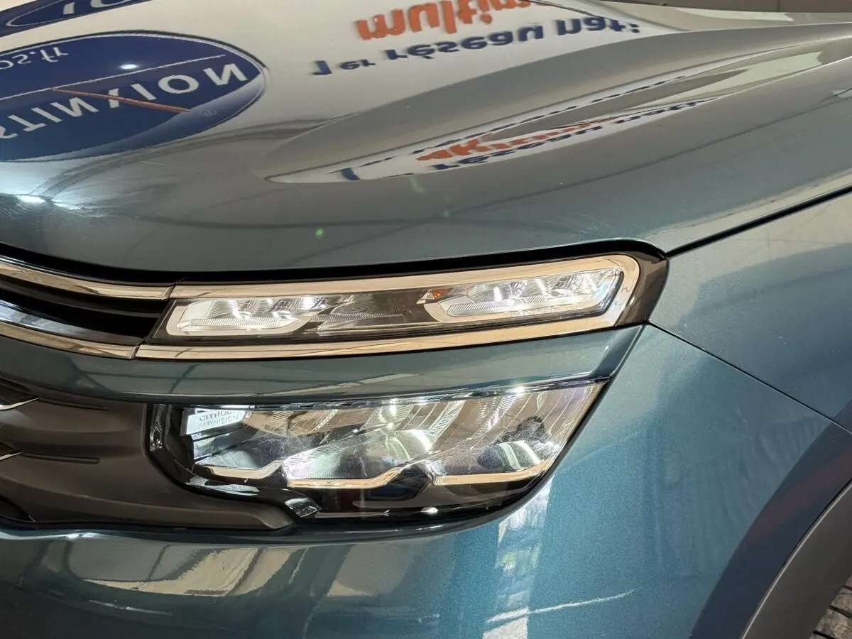 Gros plan sur le phare avant droit du Citroën C5 Aircross Hybrid 225 bleu, mettant en valeur son design LED distinctif.