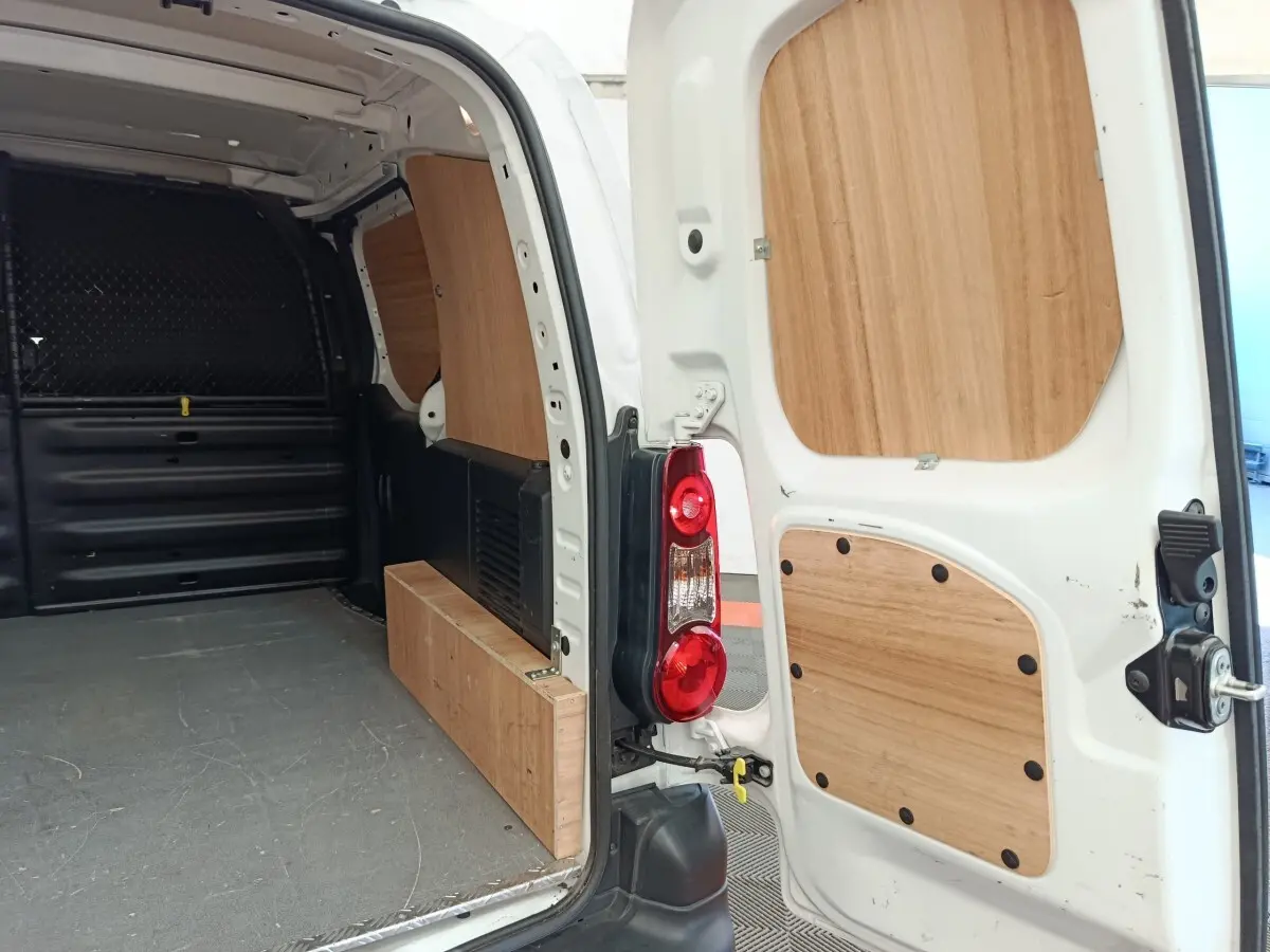 Intérieur arrière du Peugeot Partner blanc 2018, vue porte ouverte avec cloison bois et espace de chargement visible.