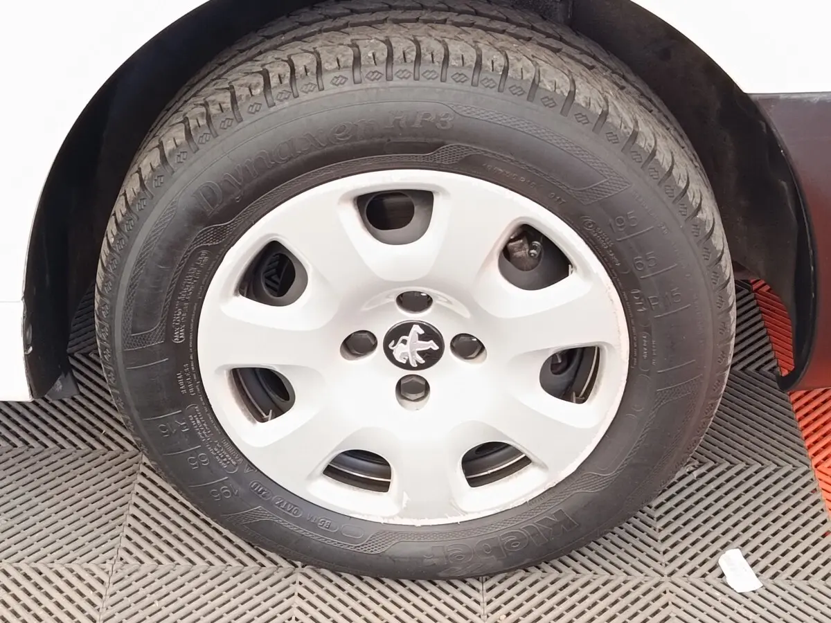 Gros plan sur la roue avant gauche blanche d’un Peugeot Partner 1.6 BlueHDi 100 Long Pro de 2018.