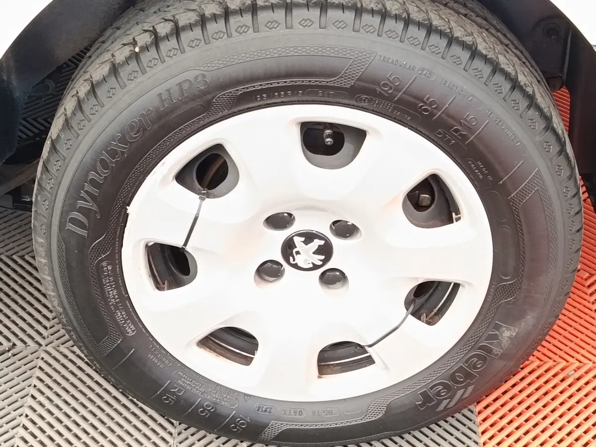Gros plan sur la roue avant droite blanche d’un Peugeot Partner 1.6 BlueHDi 100 Long Pro de 2018.