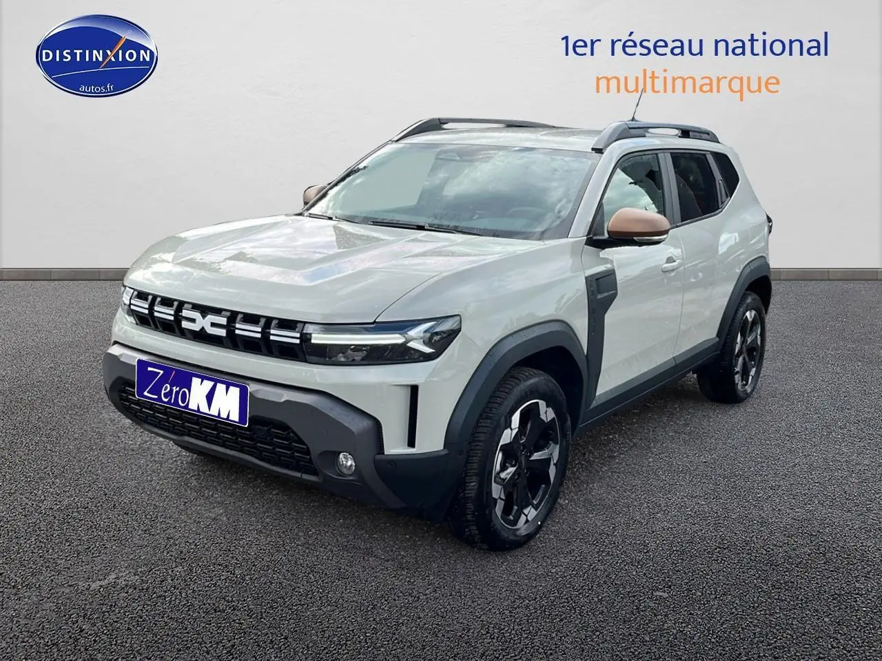 Vue 3/4 avant du Dacia Duster 2025 Sandstone avec barres de toit et rétroviseurs couleur caisse.