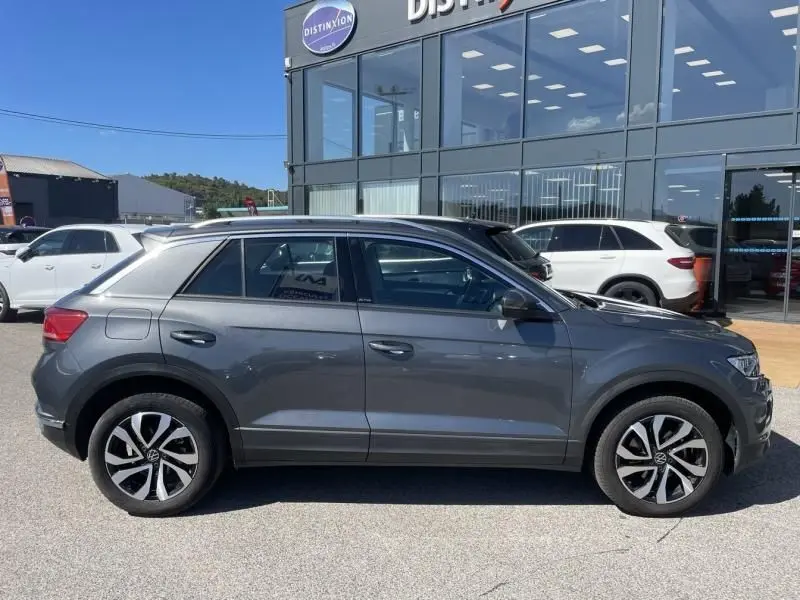 Volkswagen T-Roc gris foncé métal vue de profil côté gauche, avec jantes alliage et toit contrasté noir.