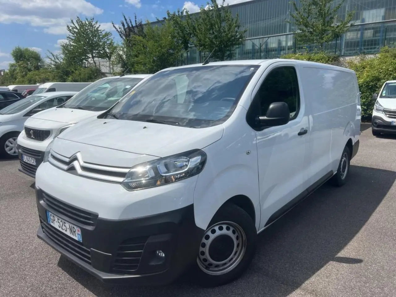 Fourgon Citroën Jumpy blanc en vue 3/4 avant droit, avec pare-chocs noirs et jantes tôles grises.