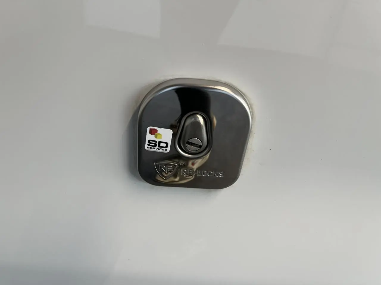 Gros plan sur la serrure de porte latérale droite en métal brillant du Citroën Jumpy XL blanc 2023.