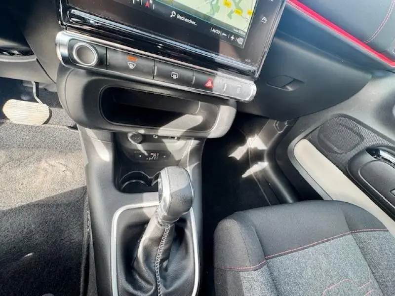 Gros plan sur la console centrale et levier de vitesse cuir de la Citroën C3 2017 avec détails intérieurs gris et rouge Aden.