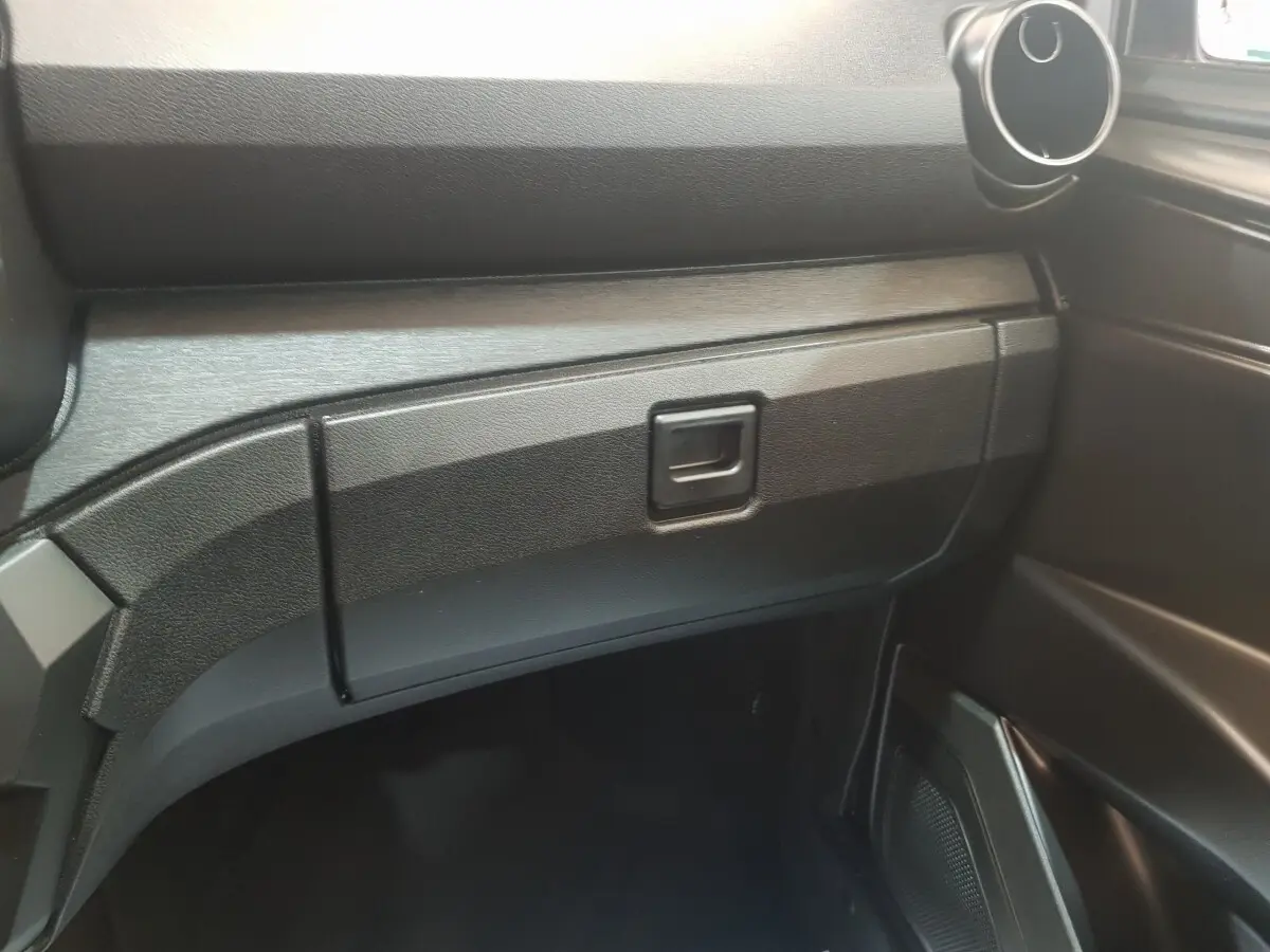 Détail de la boîte à gants côté passager de l'AIXAM AMBITION 0.5 CITY PACK 2026, intérieur noir.