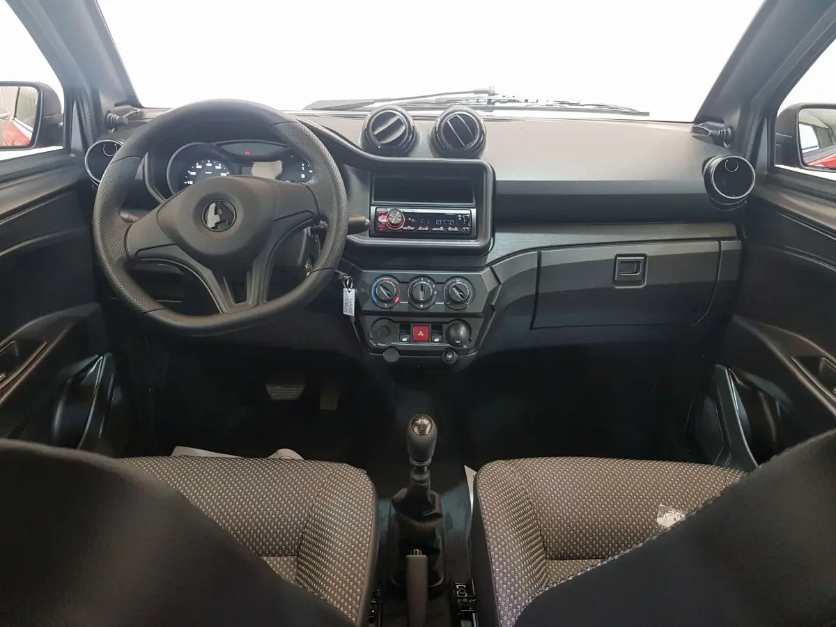 Vue intérieure frontale de l'AIXAM AMBITION 0.5 CITY PACK 2026, tableau de bord noir avec volant et rétroviseur caméra côté conducteur rouge visible.