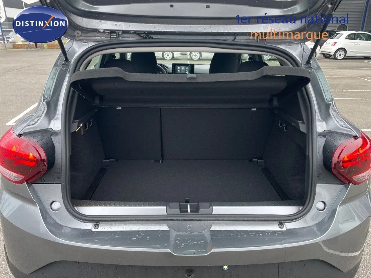 Coffre ouvert vu de l'arrière d'une Dacia Sandero Stepway 2024 gris schiste métal, montrant l'espace de chargement vide.