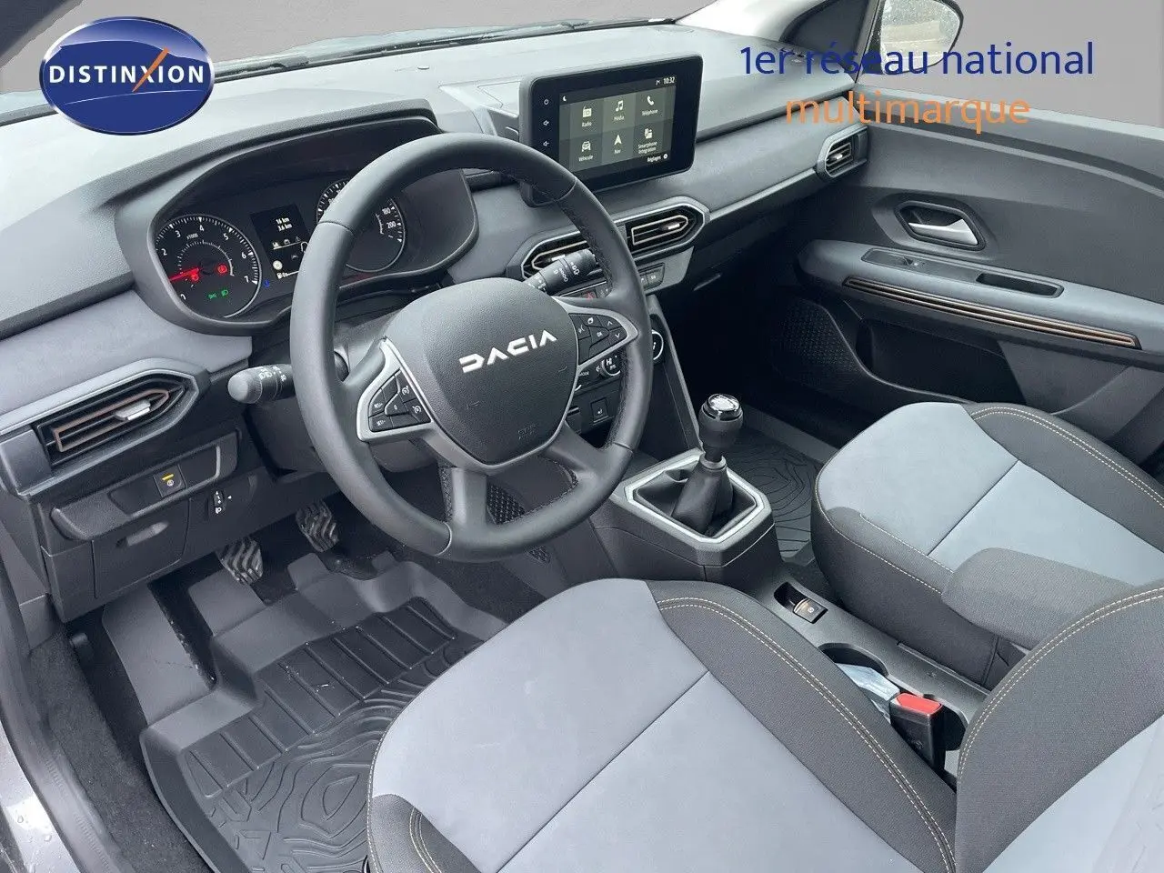 Intérieur avant de la Dacia Sandero Stepway 2024, volant multifonction, sièges gris clair et tableau de bord moderne.