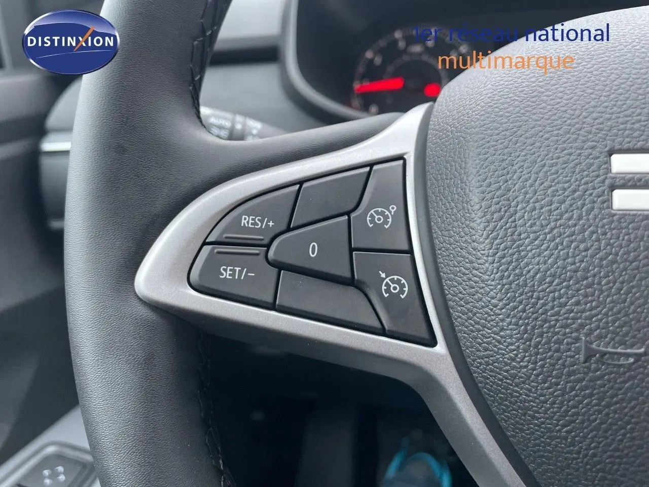 Gros plan sur les commandes de régulateur de vitesse au volant en cuir noir de la Dacia Sandero Stepway 2024.