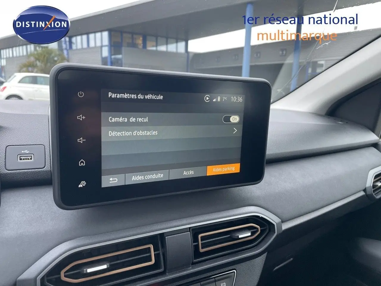 Écran tactile central affichant les paramètres de caméra de recul dans l'habitacle gris d'une Dacia Sandero Stepway 2024.