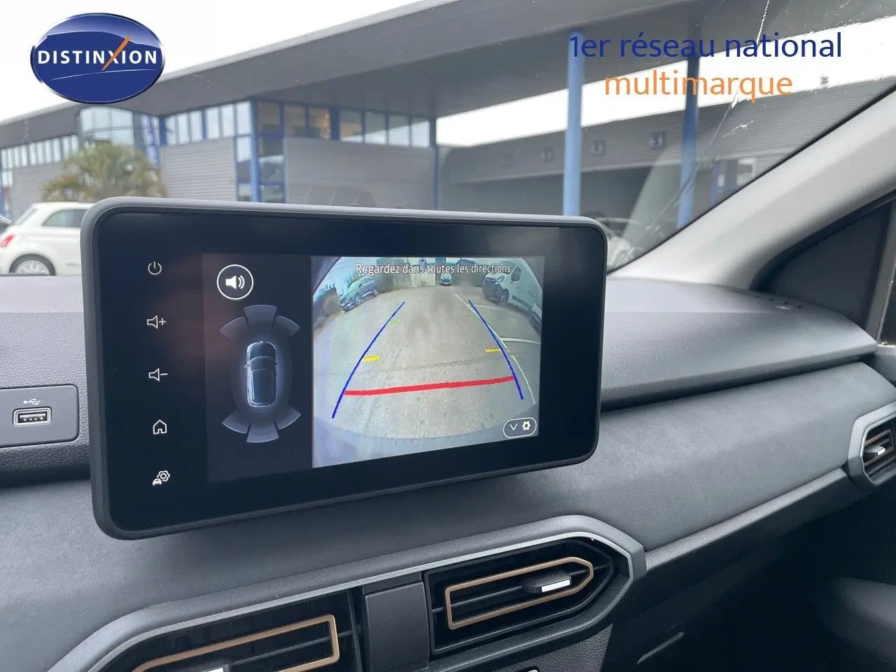 Écran tactile intérieur montrant la caméra de recul d'une Dacia Sandero Stepway gris schiste métal, tableau de bord moderne.