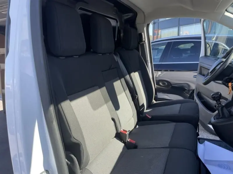 Intérieur du Peugeot Expert Fourgon blanc 2023, vue côté conducteur sur les sièges avant en tissu gris et noir.