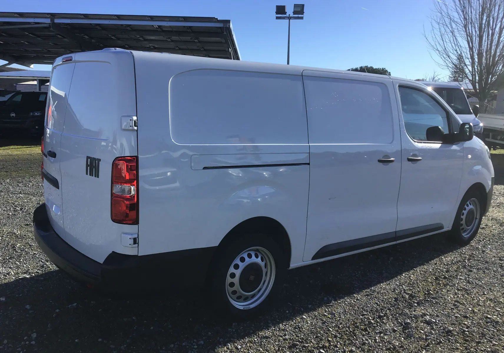 Vue 3/4 arrière droite d'un FIAT Scudo Fourgon blanc 2024 avec garde au sol réhaussée et plaque de protection tôlée.