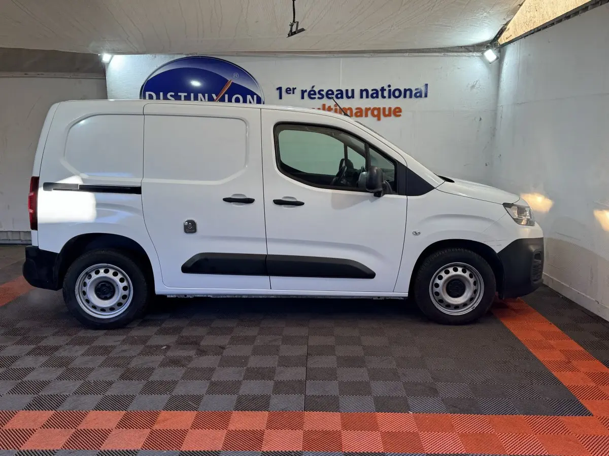 Vue de profil droit d’un utilitaire Citroën Berlingo blanc 2020 avec portes latérales pleines et jantes acier.
