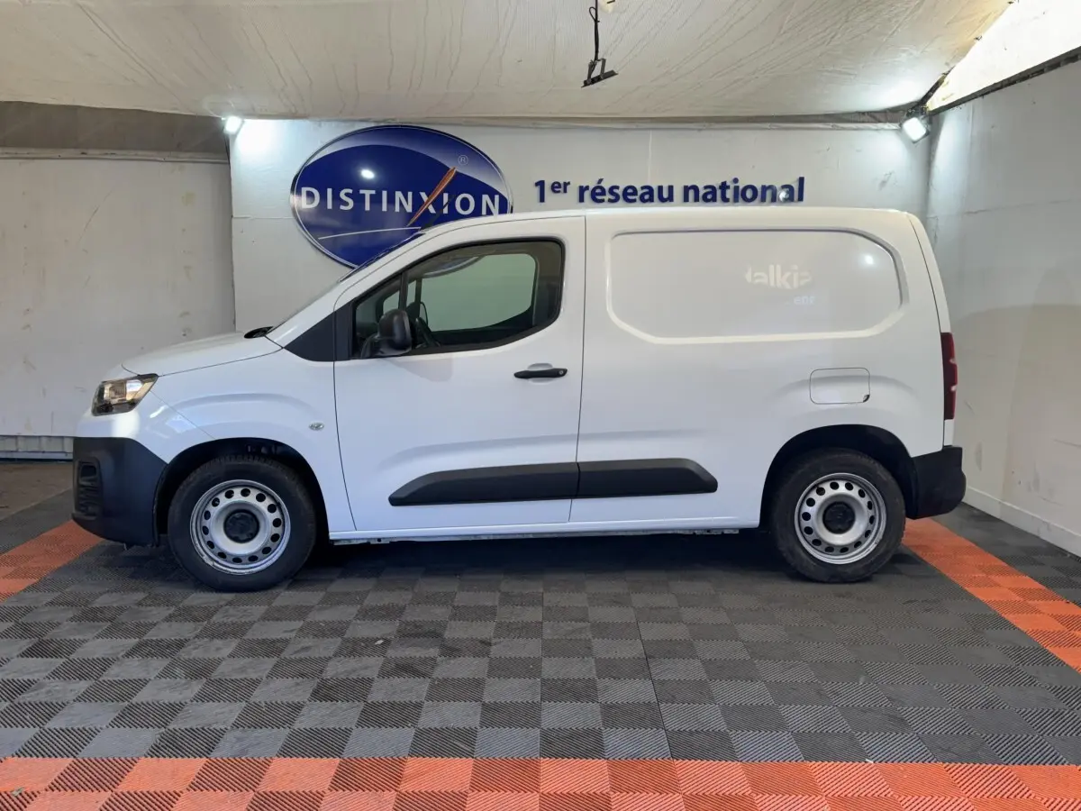 Vue de profil côté gauche d’un utilitaire Citroën Berlingo blanc avec jantes acier et protections noires sur les portes.