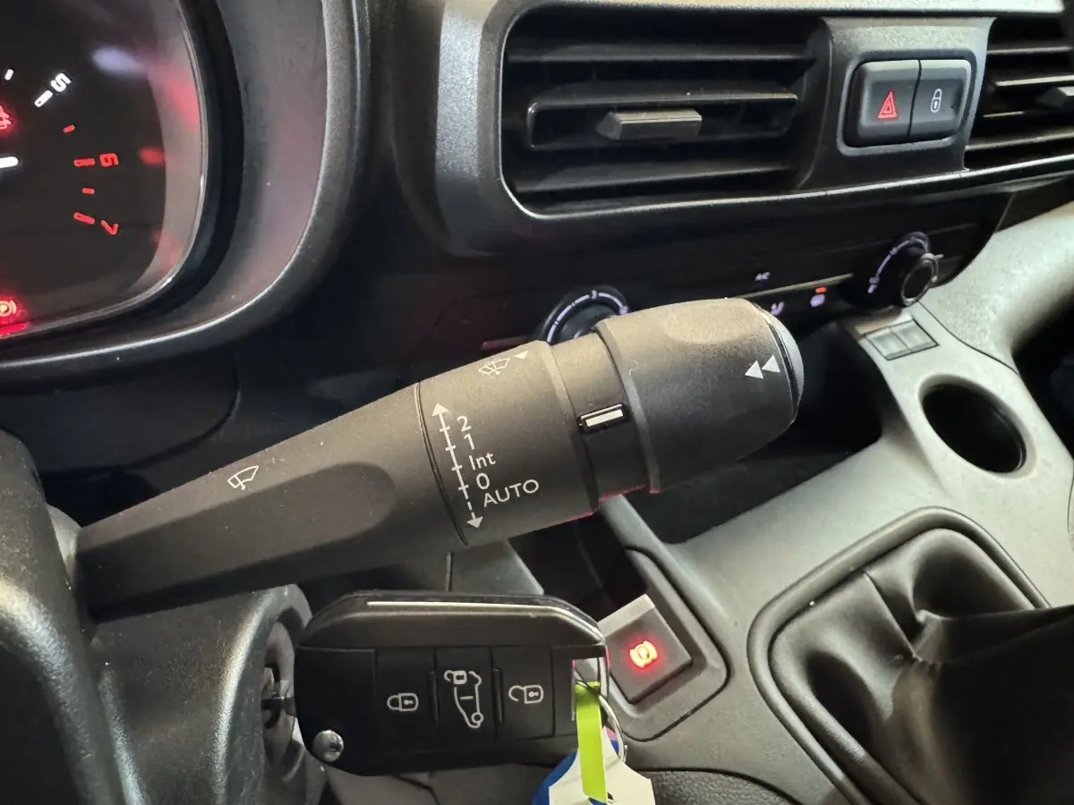 Gros plan intérieur sur la commande d’essuie-glace et la clé dans le contact d’un Citroën Berlingo blanc de 2020.