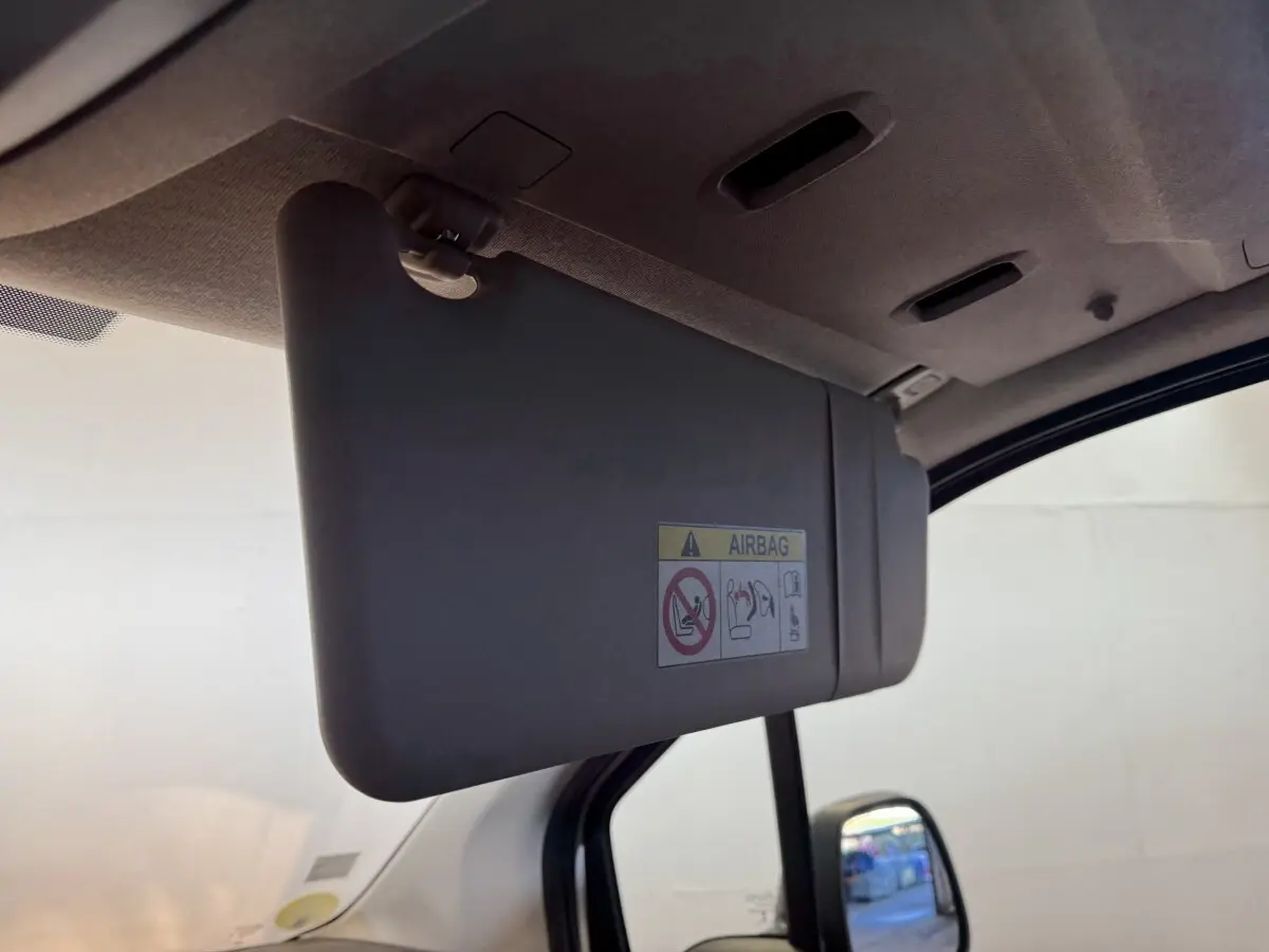 Détail du pare-soleil côté conducteur du Citroën Berlingo blanc, avec avertissement airbag visible.