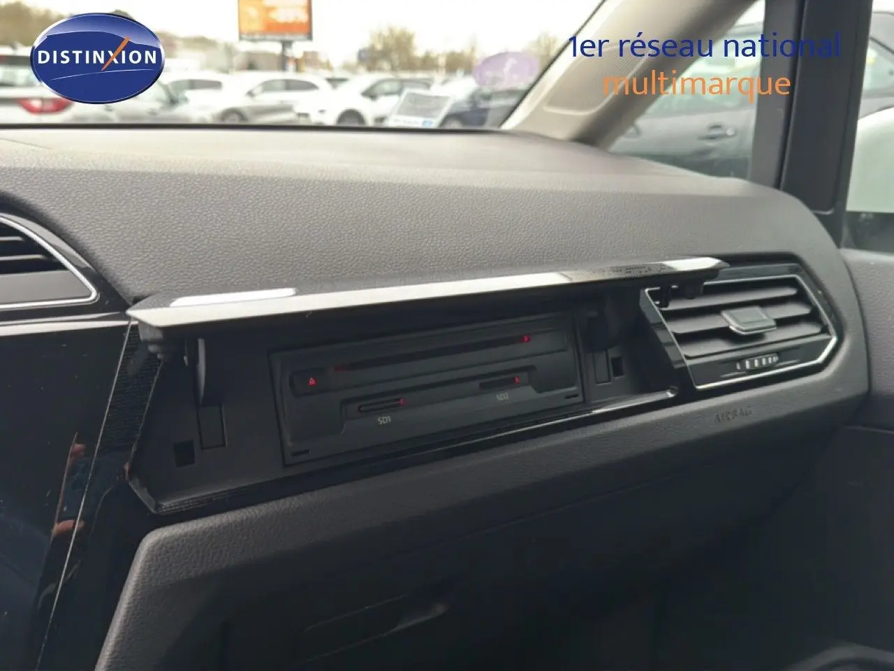 Vue intérieure du tableau de bord côté passager du Volkswagen Touran blanc de 2018, avec boîte à gants ouverte.