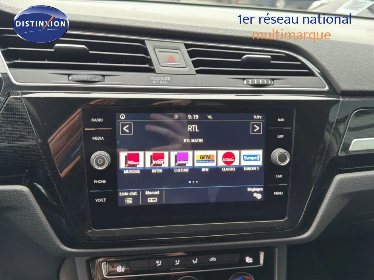 Vue rapprochée de l’écran tactile central noir du tableau de bord d’un Volkswagen Touran blanc de 2018.