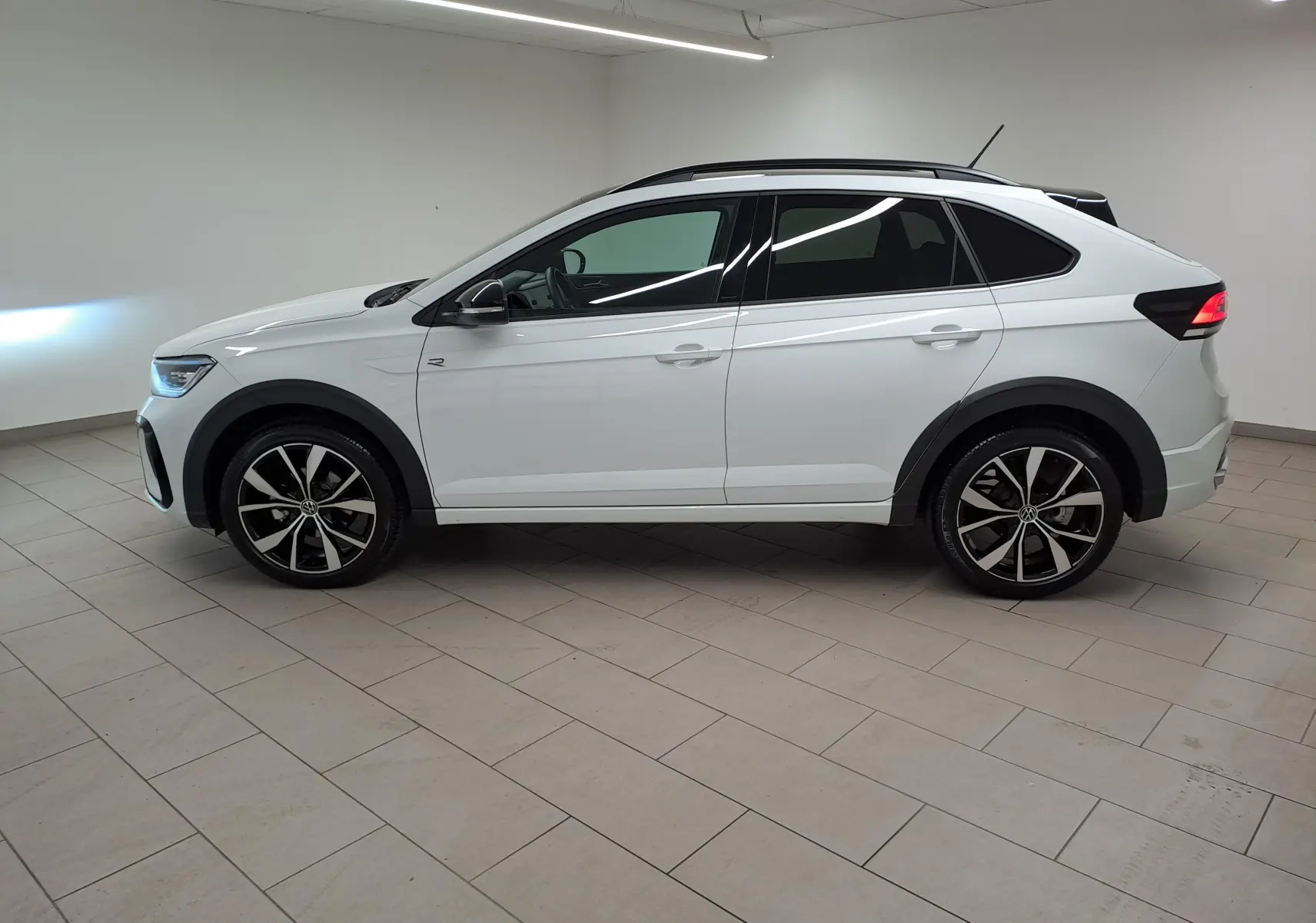 Volkswagen Taigo 1.5 TSI R-Line blanc pur toit noir vue de profil côté gauche avec jantes alliage 18 pouces.