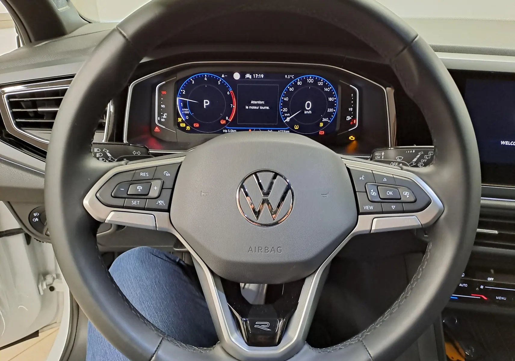 Vue rapprochée du volant multifonction noir du Volkswagen Taigo 1.5 TSI R-Line avec tableau de bord numérique allumé.